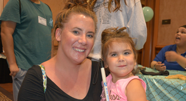 Mother and daughter smile and pose for a picture together.